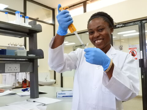 Dr Glory E Mbah using a micropipette in a scientific laboratory
