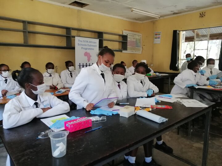 Student in a classroom reading from a white board