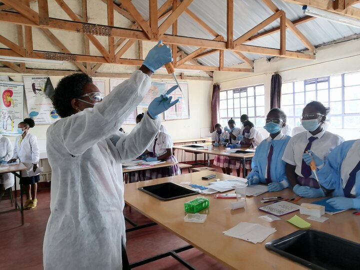 An instructor showing a classroom of students how a micro pipette works
