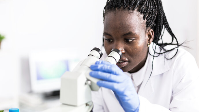 Scientist looking through a microscope.